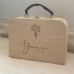 een houten koffertje met leren handvat gepersonaliseerd met naam en geboortedatum