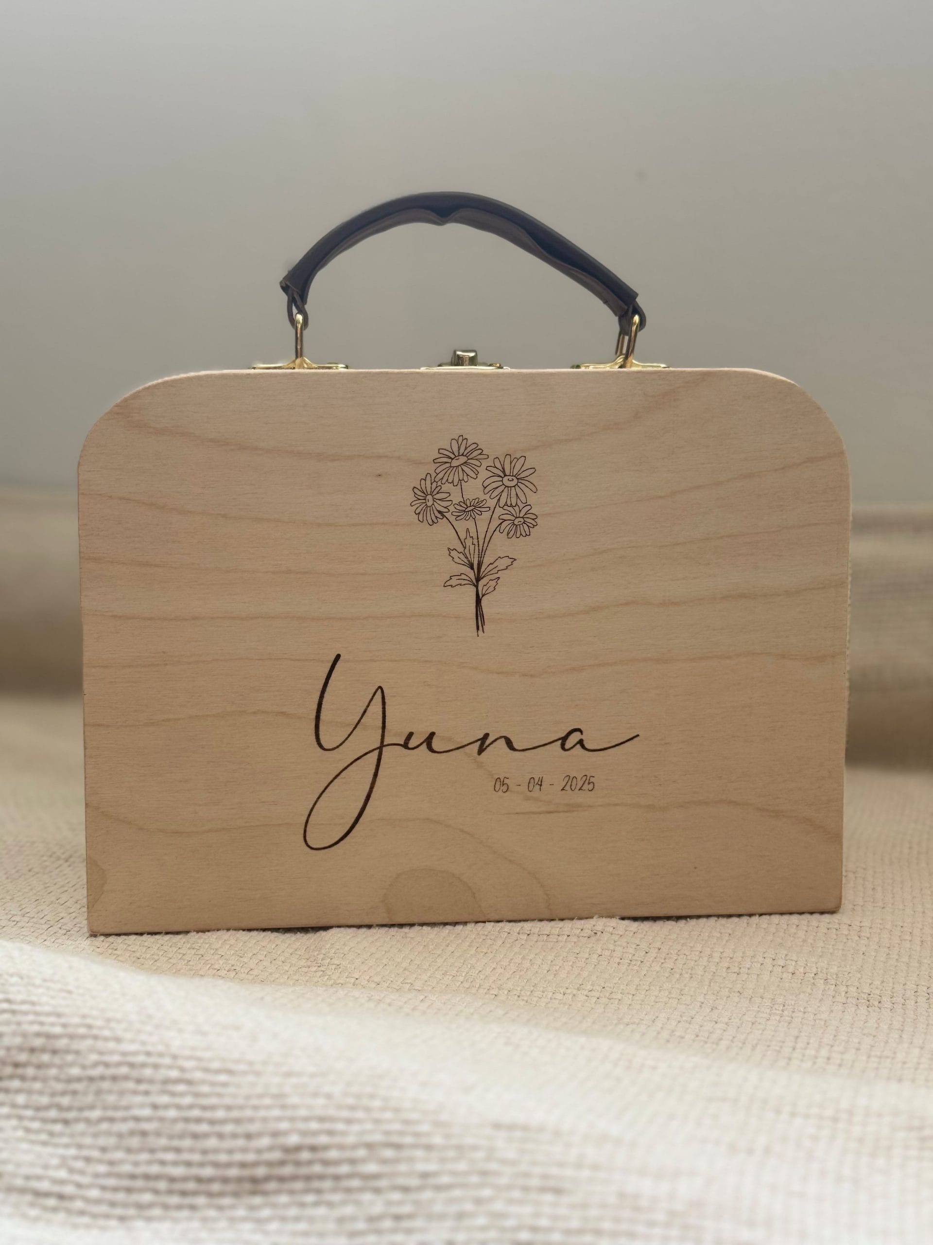 een houten koffertje met leren handvat gepersonaliseerd met naam en geboortedatum