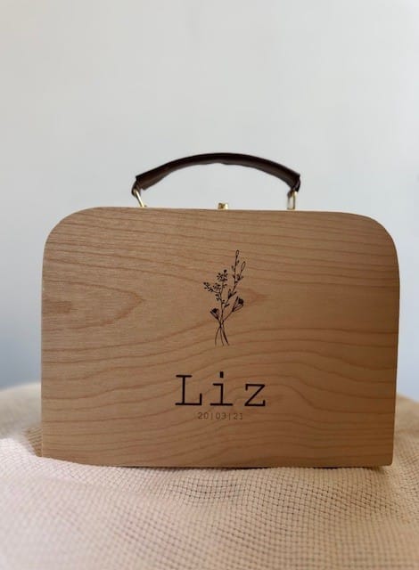 een houten koffertje met leren handvat gepersonaliseerd met naam en geboortedatum